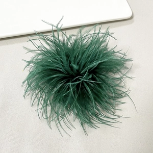 Macro detail of lush dark green ostrich feather brooch for elegant dress accessories