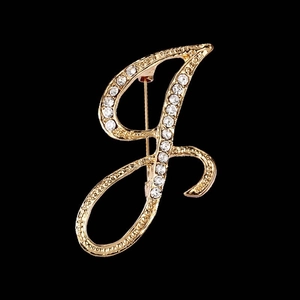 Elegant gold cursive letter J brooch with sparkling rhinestones on black background