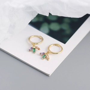 Detailed view of gold hoop earrings with hanging colorful rectangular zircon gemstones