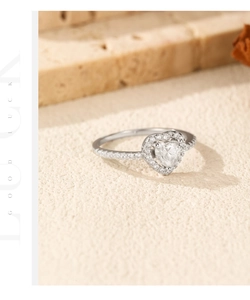 Detailed close-up of a heart-shaped moissanite ring with micro-pave 925 silver setting