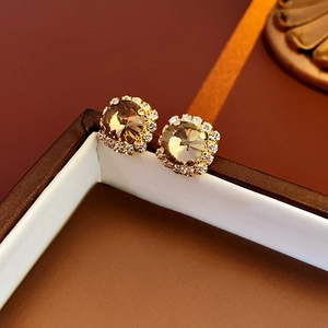 Close-up of champagne square stud earrings with pave diamond border in jewelry box