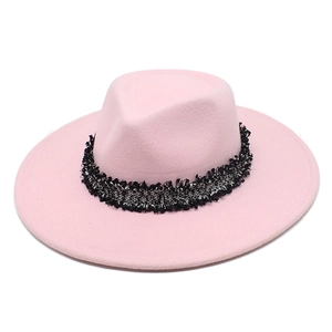 Détail d'un chapeau en feutre rose avec ruban décoratif tissé noir et blanc élégant