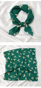Close-up of green cotton linen scarf with elegant gold leaves and white flowers