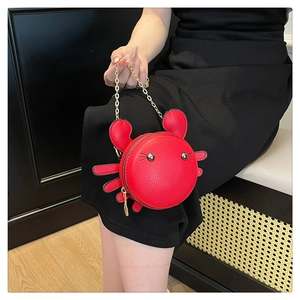 Detail of red crab mini bag with PU leather texture and golden chain strap