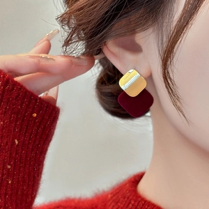 Elegant gold and burgundy flocked square drop earrings on model in minimalist setting