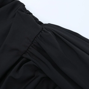 Detailed macro view of the ruched black lace dress fabric with intricate pleated design