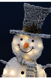 Close-up of lighted Christmas snowman with warm LED lights and pine cone detail