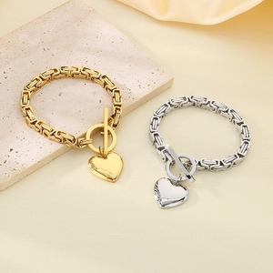 Detail of gold and silver heart pendant Byzantine chain bracelets with OT toggle clasps