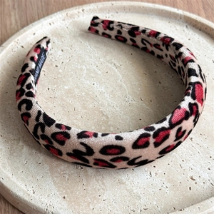 Macro detail of red and black leopard print velvet headband with handmade inner label