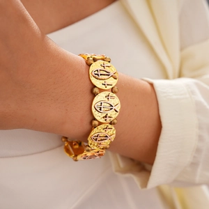 Détail d'un bracelet religieux bicolore avec croix et poisson porté au poignet