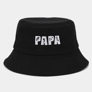 Detail of white PAPA embroidery featuring fishing silhouettes on a black cotton bucket hat