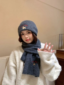 Detail of dark grey knit hat and scarf set with cute dog embroidery and red lettering