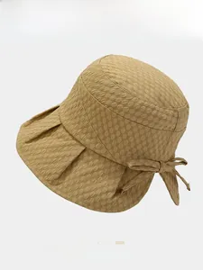 Detail of khaki bucket hat featuring bubble texture fabric and side bow decoration