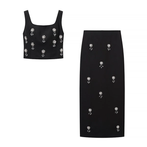 Ensemble noir deux pièces avec haut court et jupe midi ornés de broderies fleurs en cristal