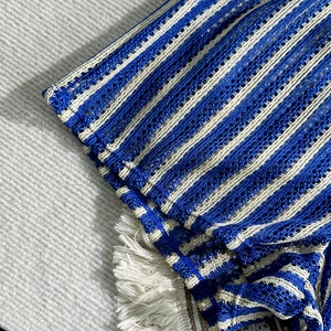 Detailed macro view of the royal blue and off-white striped crochet knit fabric texture
