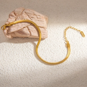 Detailed macro view of an 18k gold-plated stainless steel snake chain with lobster clasp