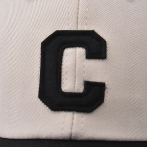 Close-up of beige washed cotton baseball cap with black embroidered letter C detail