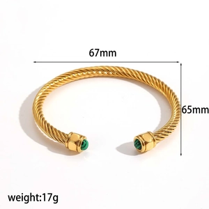 Gedrehtes Edelstahlarmband mit grünen Steinen und 67mm Größenangabe im Detail