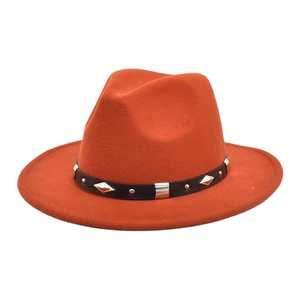Detail of orange wool fedora hat with a black belt and golden diamond studs