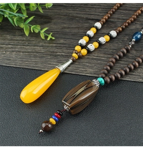 Detailed close-up of ethnic long necklaces with colorful wooden beads and unique pendants