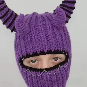 Detail of purple knitted balaclava with devil horns and silver chain punk accessories