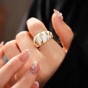 Detail of vintage enamel open ring in gold and white finish worn on finger