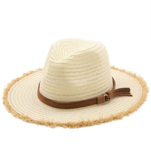Détail d'un chapeau en raphia avec un ruban en cuir marron et bordure effilochée