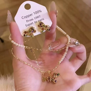 Vue détaillée de la parure licorne en perles plaqué or avec étiquettes en cuivre