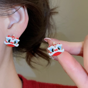 Detail of red cartoon lion dance earrings with small pearl and gold coin accents