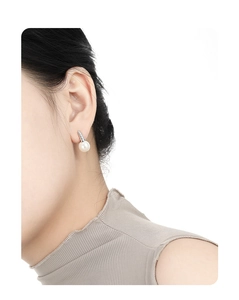 Close-up of elegant French twist silver hoop earrings with white round pearls on model