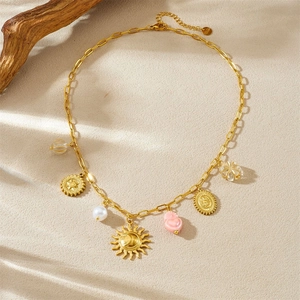 Detail of gold sun and pink heart charms on a stainless steel necklace set