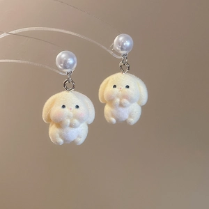 Detail view of cute flocked rabbit earrings with white faux pearls and silver hooks