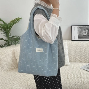 Détail du sac cabas en velours côtelé bleu clair avec motif nœud en décor intérieur