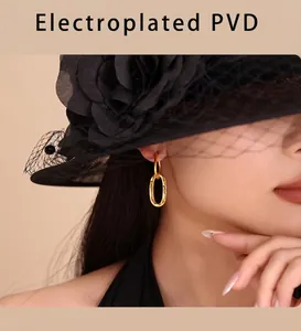 Macro detail of gold oval chain earrings with premium PVD plating on fashion model