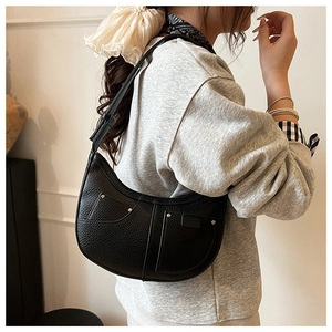 Detailansicht der schwarzen Hobo-Tasche mit Litschimuster, Nieten und zwei Fronttaschen