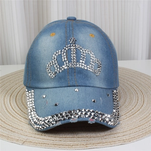 Détail d'une casquette en denim bleu clair avec strass couronne et rivets métalliques