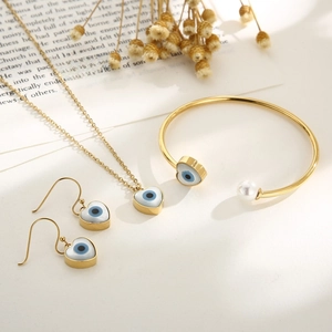 Golden titanium evil eye jewelry set with heart necklace, pearl bracelet and earrings