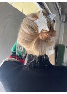Sparkly silver star hair claw clip with glitter finish shown on a model's hair