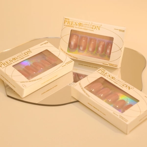Set of three boxes featuring nude pink cat-eye press-on nails in oval shape with glossy finish