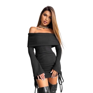 Dettaglio dell'abito in maglia nera a spalle scoperte con texture a coste e coulisse laterale