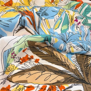 Detailed view of tropical floral printed fabric with soft twill texture and palm patterns