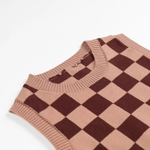 Gros plan détaillé du gilet en maille à damier marron et rose avec encolure ronde sur blanc