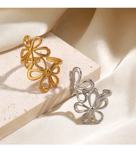 Detailed view of hollow flower rings in gold and silver on an elegant silk background