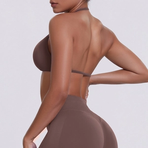 Detail of seamless brown halter sports bra and high-waisted leggings on a model