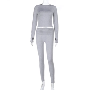 Detail of gray long-sleeved cropped top and high-waisted yoga leggings set on mannequin