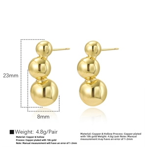 Detail view of 18k gold plated hollow triple ball stud earrings on a white background