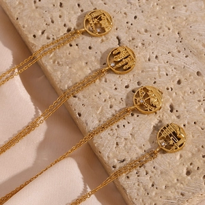Detail of gold-colored round hollow pendants with city silhouettes on stone