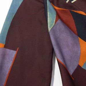 Macro detail of abstract geometric print on a long sleeve shirt with rich vibrant colors
