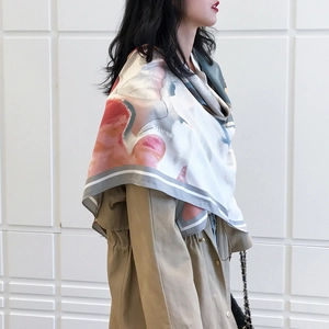 Detail of 130cm floral oil painting style silk scarf paired with a classic khaki trench coat
