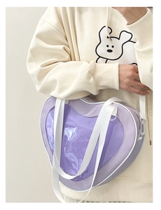 Detail of purple heart-shaped ita bag in canvas with clear panel and white strap